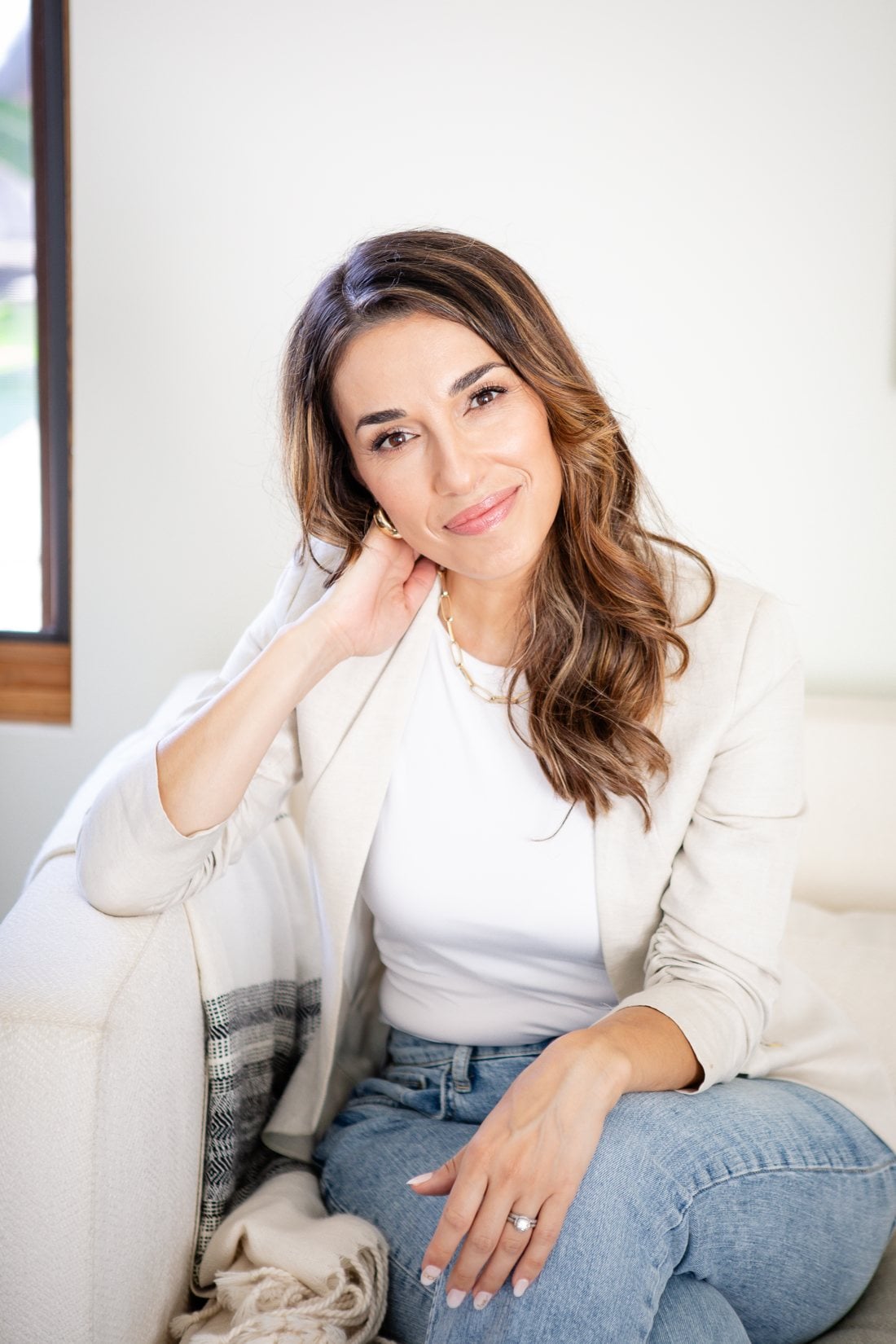 natural-facelift-sound-familiar Yana Gil de Montes smiling, seated on a cream sofa